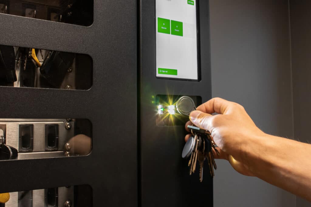 Person using RFID key fob for secure access control system with key management. Ideal for security, smart office, or technology themes.